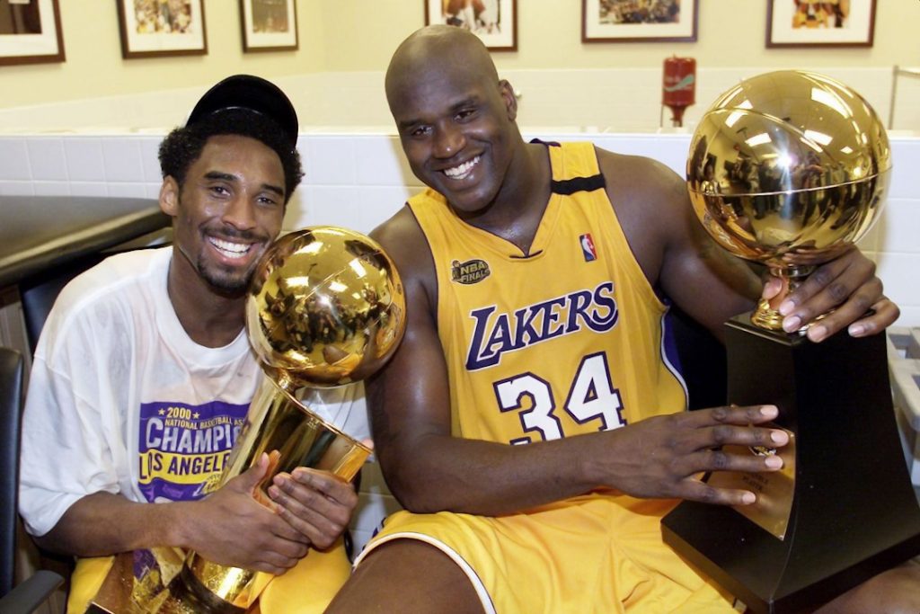 Un joven Kobe y Shaq posando con sus trofeos