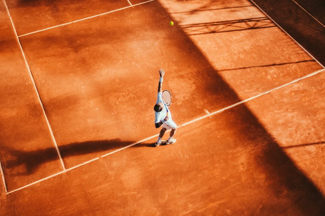 Jugador de tenis haciendo un saque.