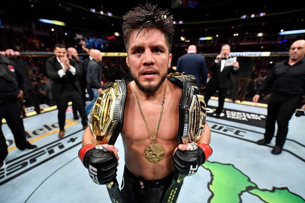 Henry Cejudo con los campeonatos de UFC
